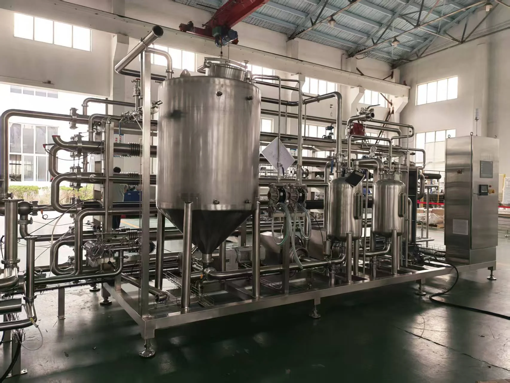 Real tube-in-tube sterilizer photograph showing product vessel, sanitary piping and horizontal tube sections